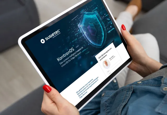 Person hält ein Tablet mit einer blau gestalteten Sicherheitssoftware-Oberfläche.
