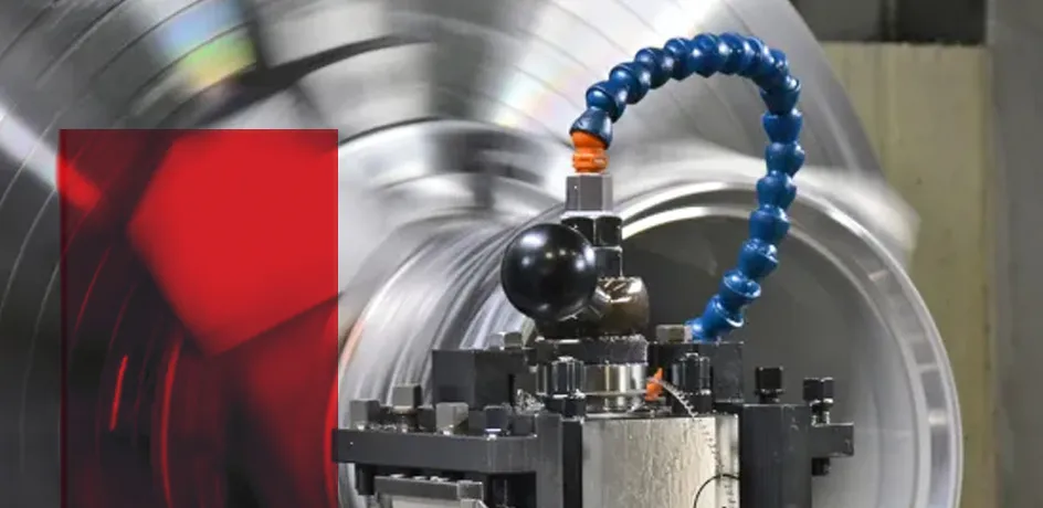 Teilansicht eines Teilchenbeschleunigers mit blauem Kabel und roten sowie silbernen Bauteilen.